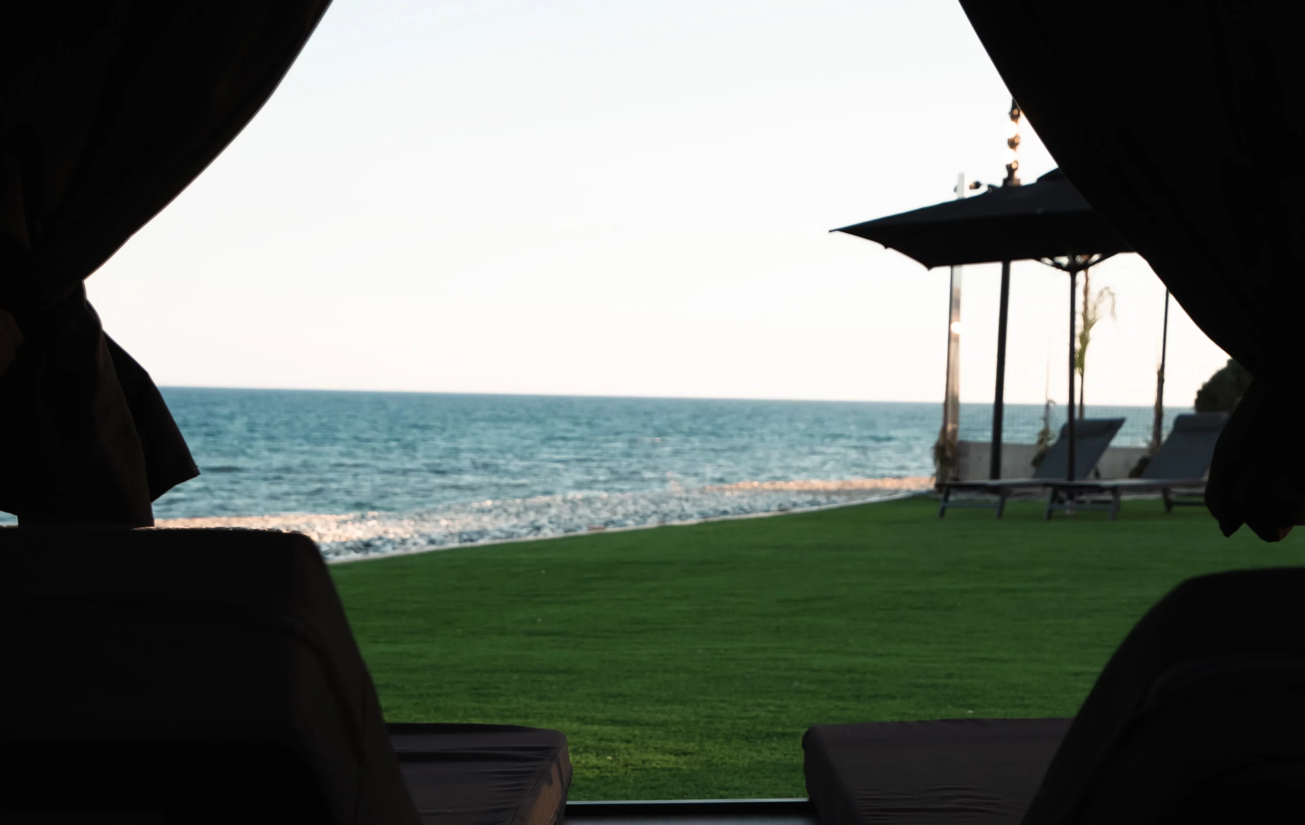 Private shaded gazebo overlooking the outdoor relaxation spaces and Mediterranean Sea at NOE Suites