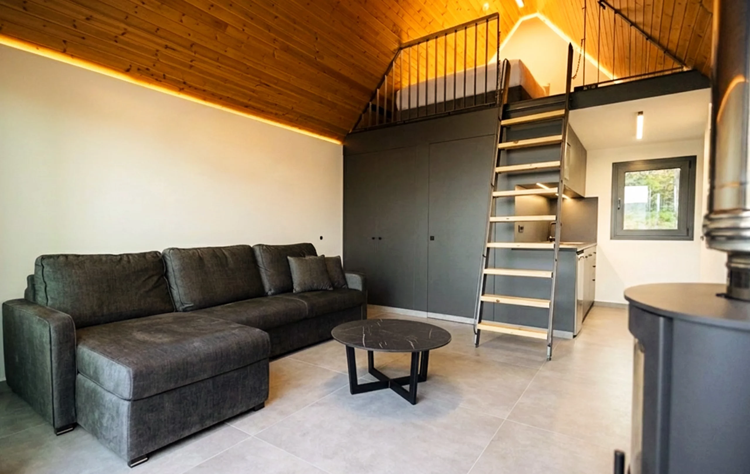 Contemporary suite living area with loft bedroom, sofa bed and kitchenette at NOE Suites