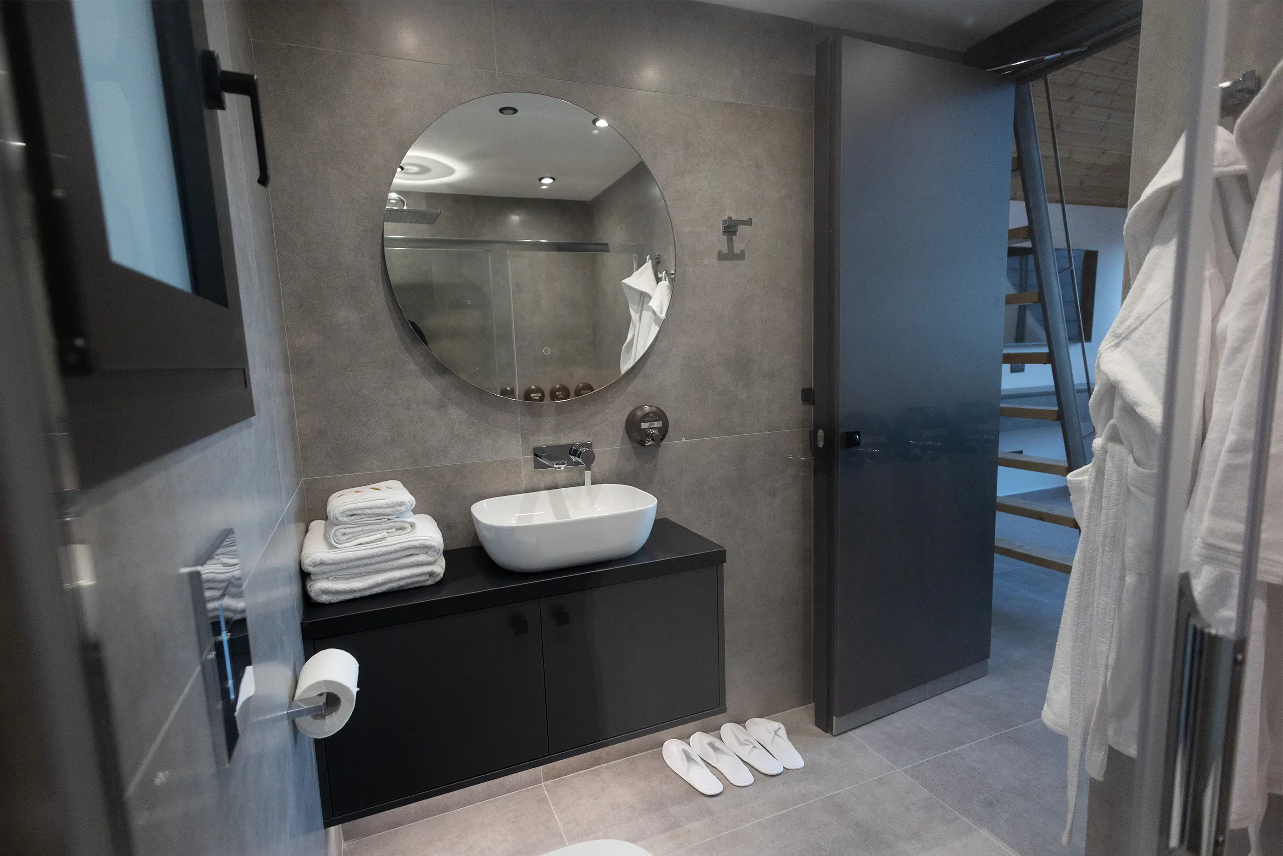 Complete bathroom at NOE Suites with basin, mirror and guest amenities