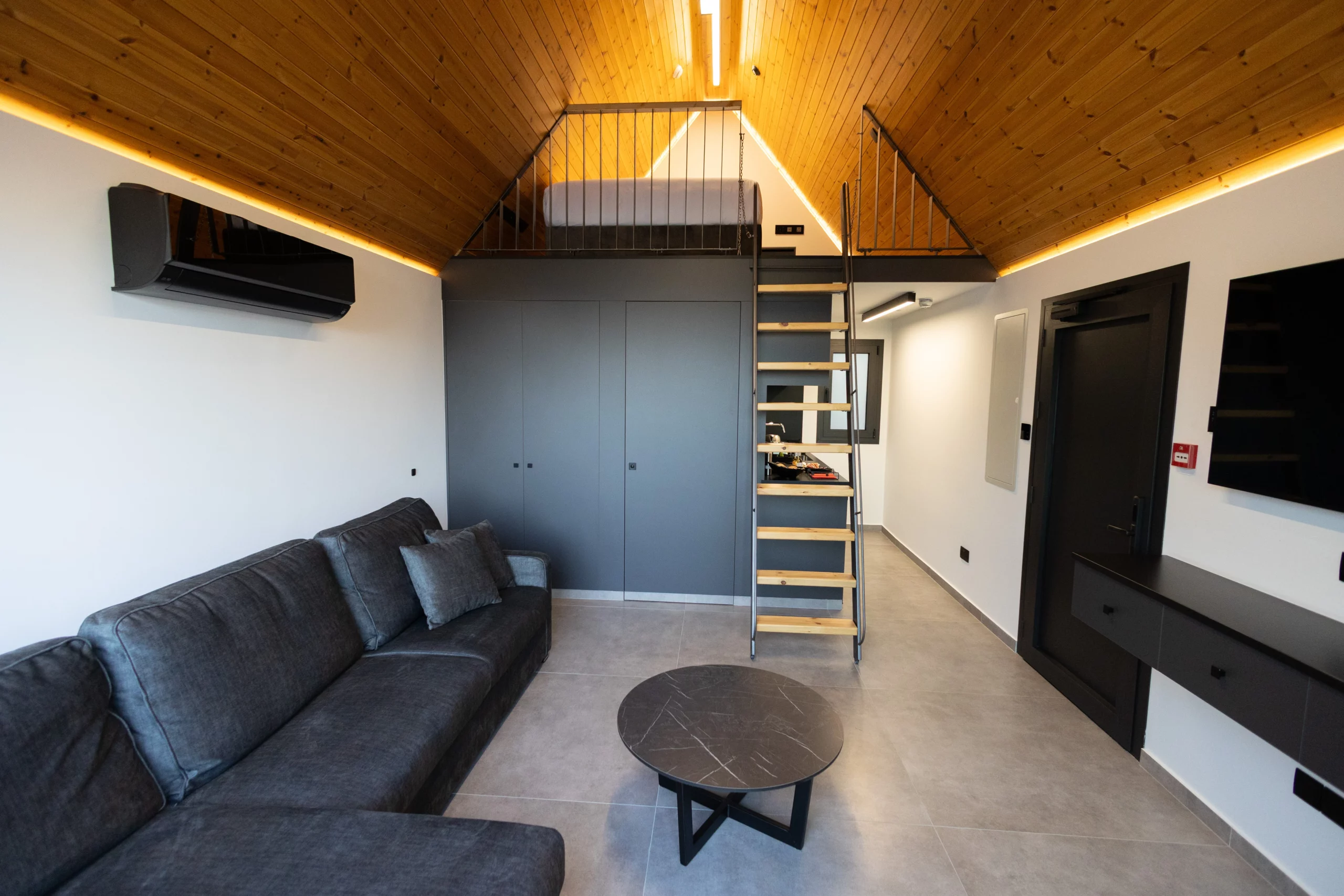 Bright NOE Suites interior with living area, staircase and upper sleeping level