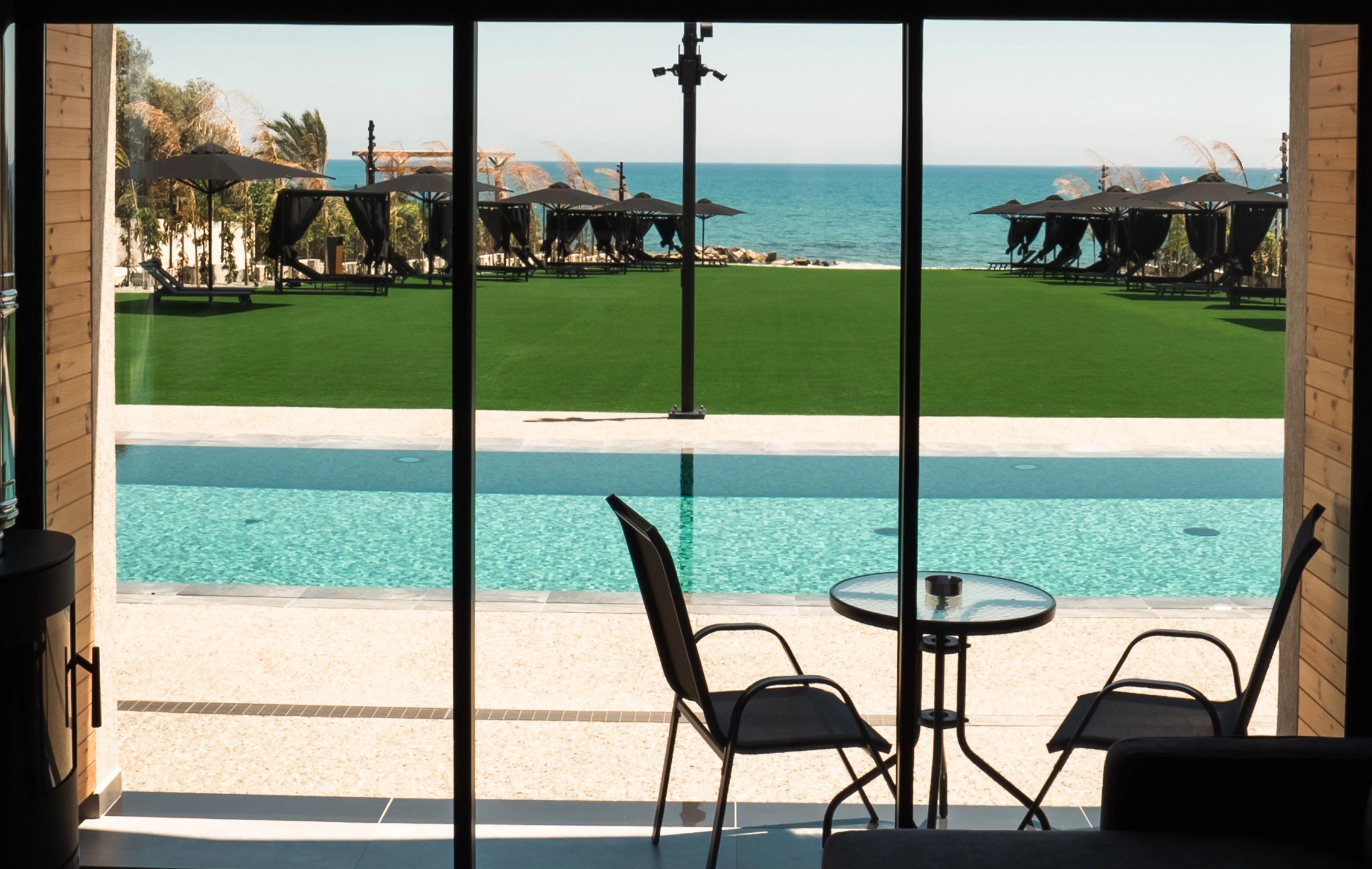 View towards the shared pool, outdoor relaxation area and sea from pool level