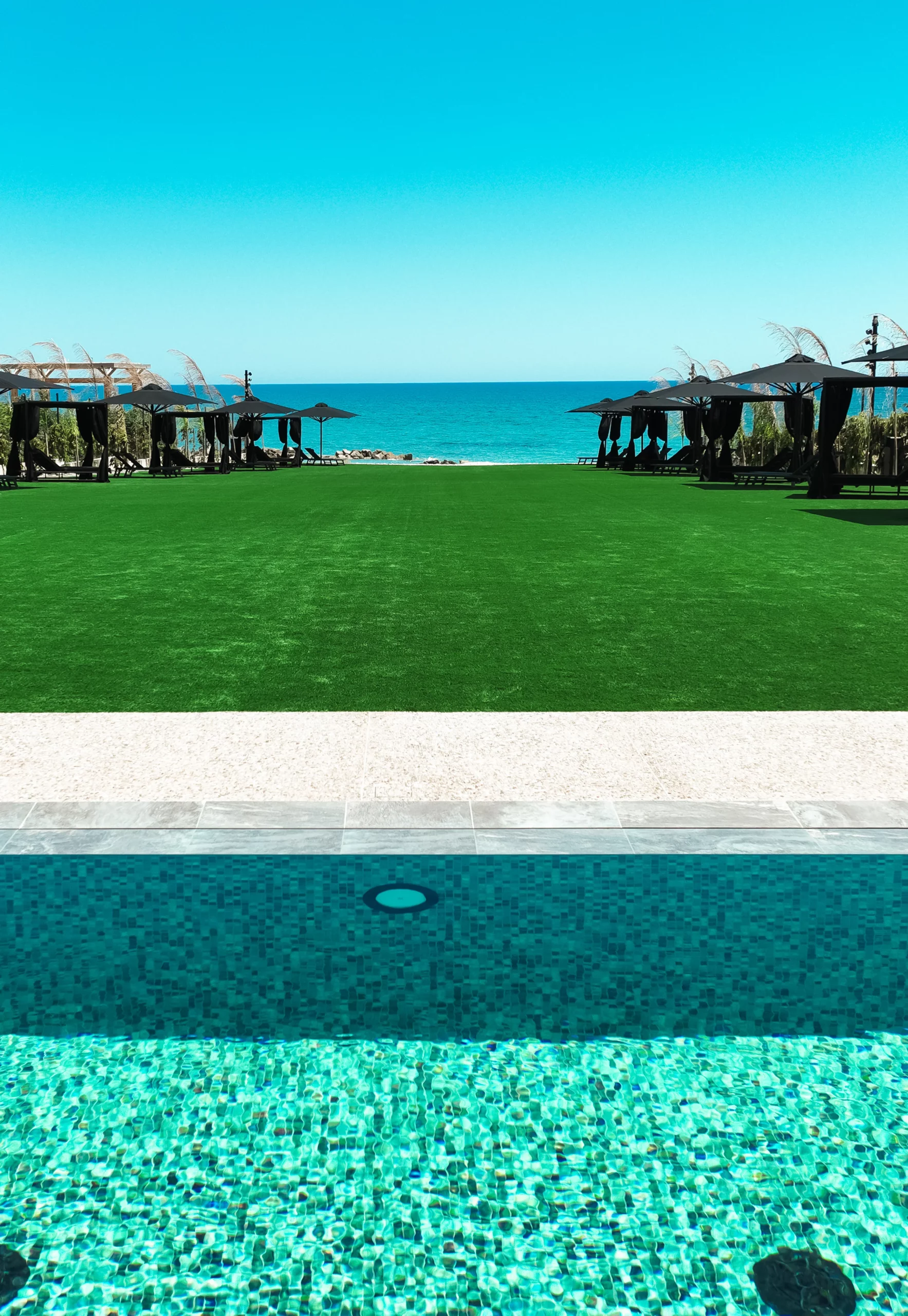Swimming pool and outdoor relaxation spaces overlooking the Mediterranean Sea at NOE Suites